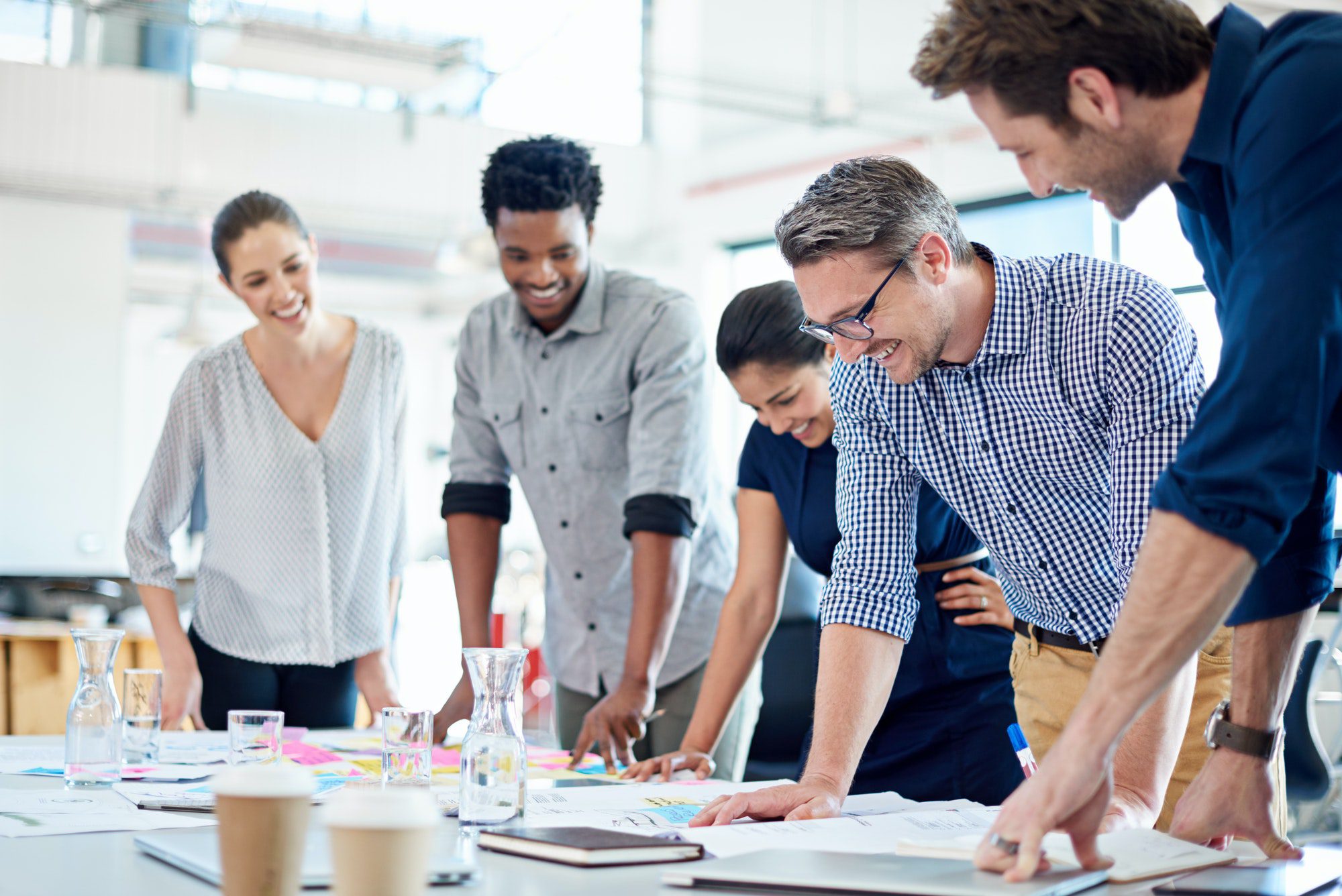 Group of diverse professionals gathered at a table to look at a strategic plan