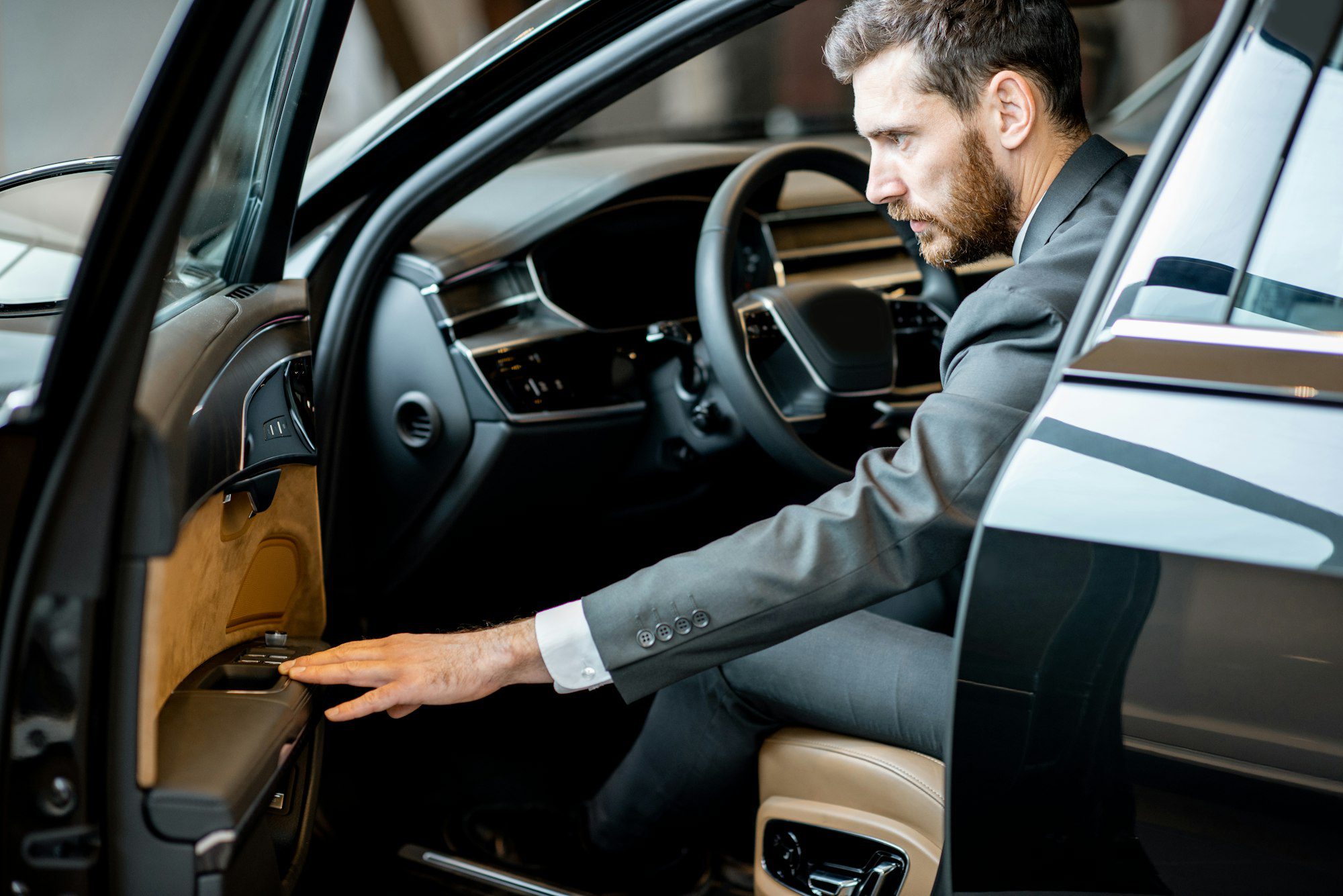 Businessman in the luxury car at the showroom